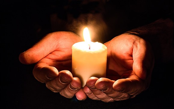 Hands holding candle